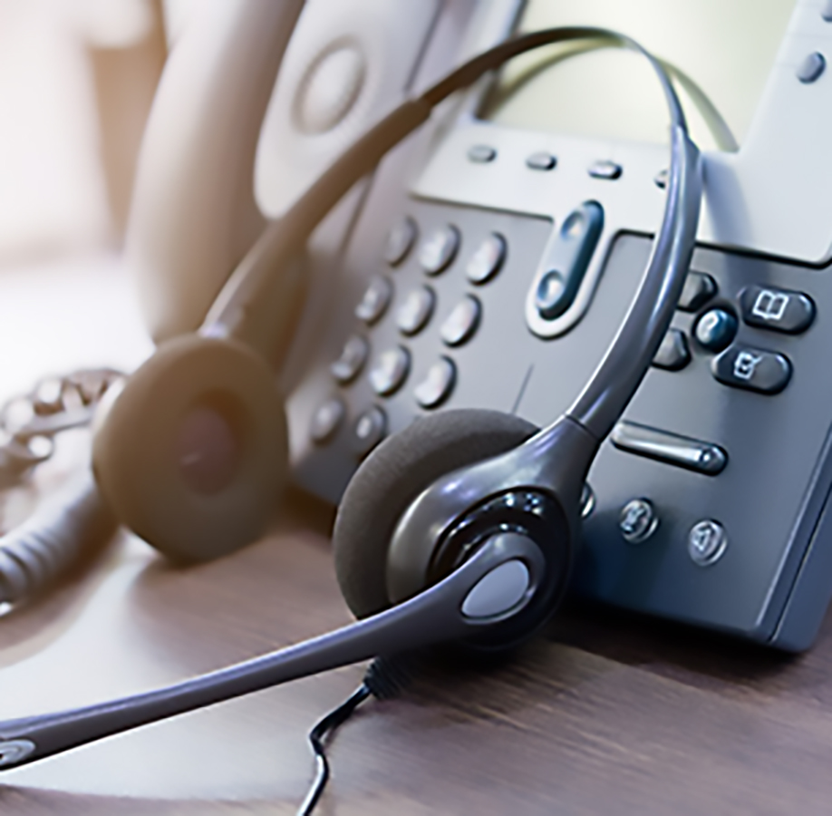 Sie haben Fragen? Stimmungsbild Kundenservice: Telefon mit angelehntem Headset